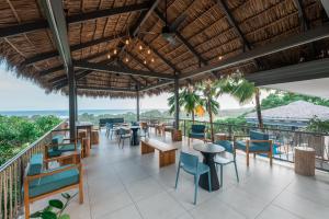 ein Restaurant mit Tischen und Stühlen auf einem Balkon in der Unterkunft Marala Hotel in Esterillos