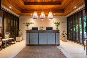 an office lobby with a reception desk and potted plants at Marala Hotel in Esterillos