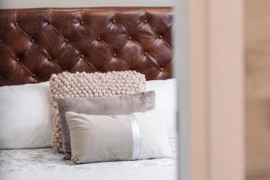 a bed with a brown leather headboard and pillows at Le 5 Terre La Spezia in La Spezia