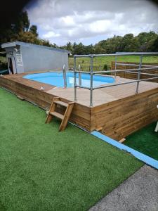 a large wooden deck with a swimming pool at LESTEPHANIA in Le Moule