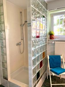 a bathroom with a shower and a blue chair at FeWo Sunshine in Heringsdorf