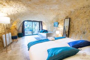 a bedroom in a cave house with a large bed at Troglo Dit Gîte 4* proche d'Amboise in Nazelles