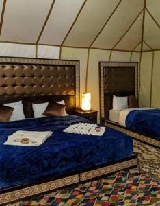 a bedroom with two beds in a tent at Blue Sky Luxury Camp in Merzouga