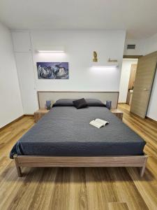 a bedroom with a large bed with a blue blanket at appartamento la chiocciola in Cavallino-Treporti
