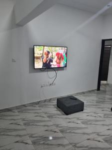 a television on a wall in a white room at nanas@TEMA C11 in Tema