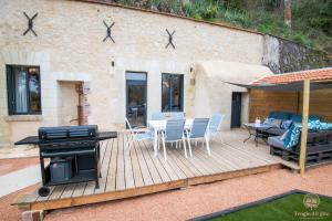 a deck with a grill and a table and chairs at Troglo Dit Gîte 4* proche d'Amboise in Nazelles