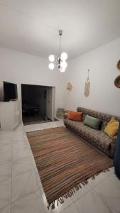 a living room with a couch and a flat screen tv at La Casa d'Olhão in Quelfes