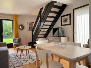 a living room with a table and a staircase at Le Criollo in Apremont