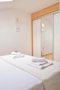 um quarto com uma cama branca e um espelho em Apartment Sea view em Kali