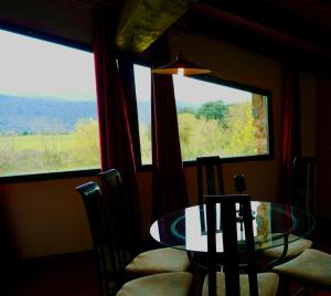 a dining room with a table and two windows at APARTAMENTO GIRASOL in Argelaguer