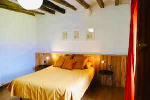 a bedroom with a bed with yellow sheets and orange pillows at APARTAMENTO GIRASOL in Argelaguer