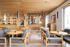 Evora Olive Hotel في ايفورا: غرفة طعام مع طاولات وكراسي خشبية