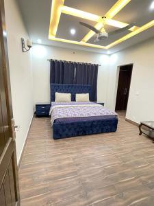 a bedroom with a blue bed and a ceiling fan at Bahria Residency 1 in Islamabad