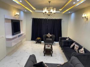 a living room with couches and a chandelier at Bahria Residency 1 in Islamabad