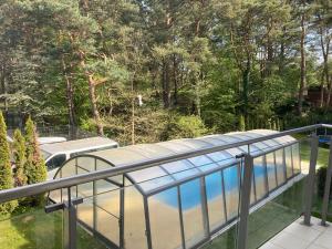 a balcony with a swimming pool and trees at Apartamenty VILLA 4 PORY ROKU in Jastrzębia Góra