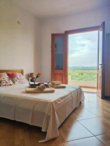 a bedroom with a large bed and a large window at Villa Apollonia Guest House in Fier