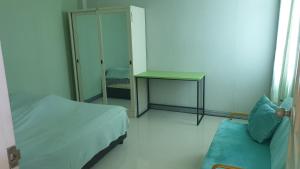 um quarto com duas camas, uma mesa e um espelho em บ้านOrman em Chumphon