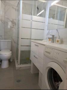 y baño blanco con aseo y lavadora. en Chania Mini Villas, en Skinés