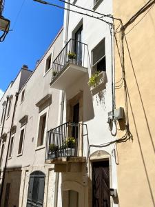 un edificio blanco con 2 balcones y flores. en Appartamento Domarì en Turi