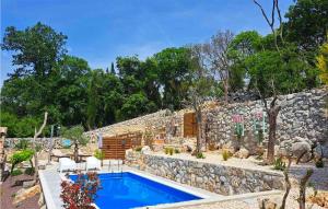 una piscina frente a una pared de piedra en Nice Home In Cres With Wifi en Cres