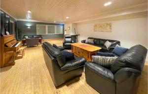 sala de estar con muebles de cuero y piano en Awesome Apartment In Mesnali With Kitchenette, en Mesnali