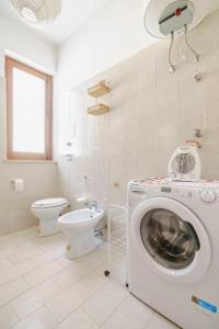uma casa de banho com uma máquina de lavar roupa e um WC em La Pineta al Mare em Érice