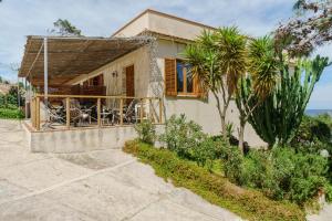 a house with a porch with a palm tree at La Pineta al Mare in Erice