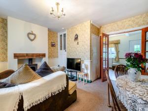 a bedroom with a bed and a living room at Lilac Cottage in Grosmont