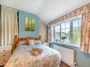 een slaapkamer met een bed met een hond erop bij Lilac Cottage in Grosmont