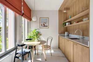 a kitchen with a table and chairs and a window at Baltic Wave Boutique Apartments with sauna and gym in Sopot