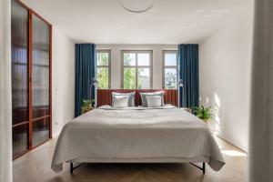 sypialnia z dużym łóżkiem z niebieskimi zasłonami w obiekcie Baltic Wave Boutique Apartments with sauna and gym w mieście Sopot