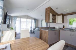 a kitchen and living room with a table and chairs at Great Caravan With Decking Southview Holiday Park In Skegness Ref 33002v in Skegness
