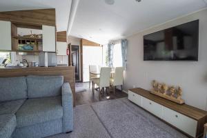 sala de estar con sofá y comedor en Great Caravan With Decking Southview Holiday Park In Skegness Ref 33002v en Skegness