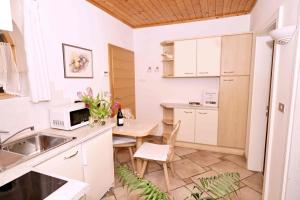 eine Küche mit einer Spüle und einem Tisch mit einer Mikrowelle in der Unterkunft Burgunderhof in Montan