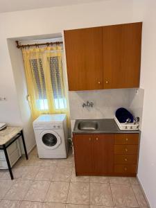 a kitchen with a sink and a washing machine at domenica in Armenistis