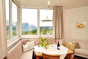 uma sala de estar com uma mesa e uma grande janela em Burgunderhof em Montagna