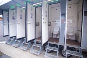 a row of toilet stalls in a building at Easy Camping Belgium in Stavelot