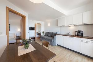 a kitchen and living room with a couch and a table at Panorama Residence Schlossblick - Apartments Erdgeschoss in Rodengo