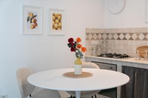a white table in a kitchen with a vase of flowers at Dimora Santa Caterina in Polignano a Mare