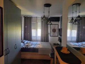 um pequeno quarto com uma cama e uma mesa em Studio Sunset em Voždivac