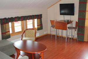 a living room with a tv and a table and chairs at Jergul Astu in Karasjok