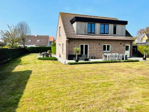 una casa con un gran patio delante de ella en Maison - Le Sable Doux, en Middelkerke