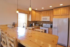 cocina con mesa de madera y nevera blanca en Nordic Lodge, en Steamboat Springs