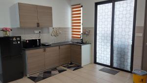 uma cozinha com um frigorífico preto e uma janela em TL145 The Strata em Kajang