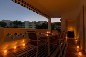 un tavolo e sedie su un balcone con luci di MARBELLA BANUS SUITES - Banus Playa Rocio Beachfront Complex a Marbella