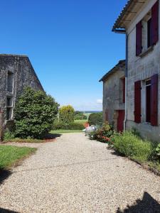 a pathway leading to a stone house and a building at Maison Rouge in Montagne