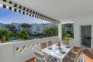 a dining room with a table and chairs on a balcony at MARBELLA BANUS SUITES - Banus Playa Rocio Beachfront Complex in Marbella