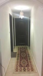 a hallway with a rug in front of a black door at شقه مفروشه سوبر ديلوكس in Amman