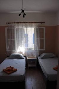 a bedroom with two twin beds and a window at Evdilos apartments with a view in Evdilos