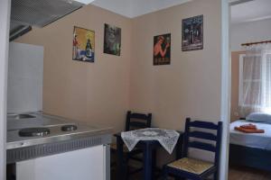 a kitchen with a sink and a table and chairs at Evdilos apartments with a view in Evdilos